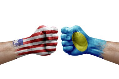 Two hands punch to each others on white background. Country flags painted fists, conflict crisis concept between liberia and palau