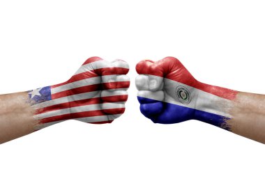 Two hands punch to each others on white background. Country flags painted fists, conflict crisis concept between liberia and paraguay