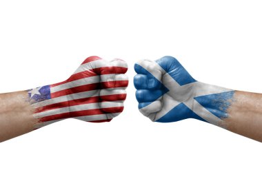 Two hands punch to each others on white background. Country flags painted fists, conflict crisis concept between liberia and scotland