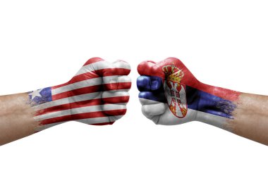 Two hands punch to each others on white background. Country flags painted fists, conflict crisis concept between liberia and serbia