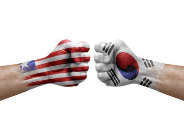 Two hands punch to each others on white background. Country flags painted fists, conflict crisis concept between liberia and south korea