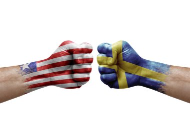 Two hands punch to each others on white background. Country flags painted fists, conflict crisis concept between liberia and sweden