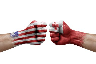 Two hands punch to each others on white background. Country flags painted fists, conflict crisis concept between liberia and tonga