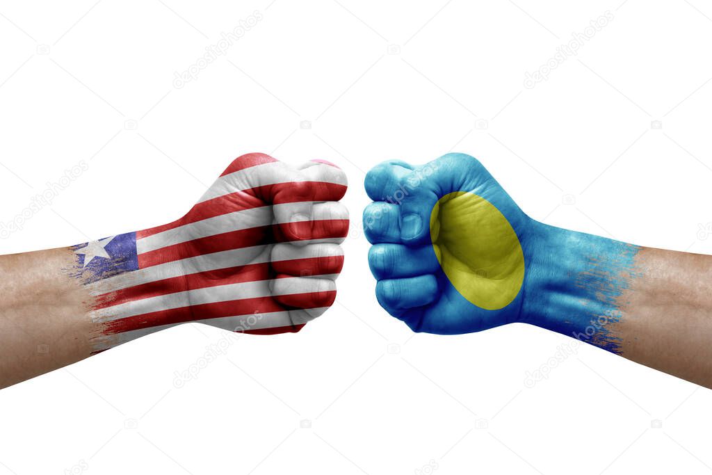 Two hands punch to each others on white background. Country flags painted fists, conflict crisis concept between liberia and palau