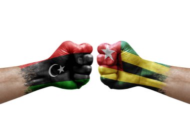 Two hands punch to each others on white background. Country flags painted fists, conflict crisis concept between libya and togo