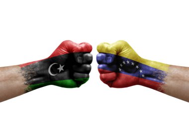 Two hands punch to each others on white background. Country flags painted fists, conflict crisis concept between libya and venezuela