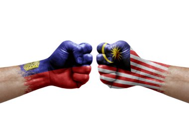 Two hands punch to each others on white background. Country flags painted fists, conflict crisis concept between liechtenstein and malaysia