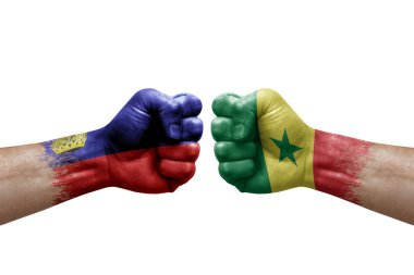 Two hands punch to each others on white background. Country flags painted fists, conflict crisis concept between liechtenstein and senegal
