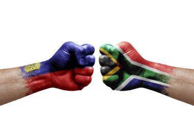 Two hands punch to each others on white background. Country flags painted fists, conflict crisis concept between liechtenstein and south africa