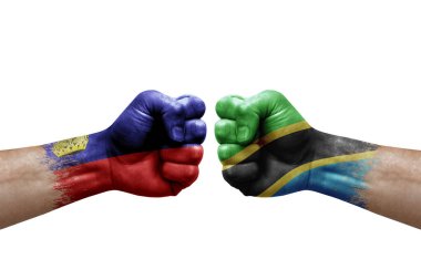 Two hands punch to each others on white background. Country flags painted fists, conflict crisis concept between liechtenstein and tanzania