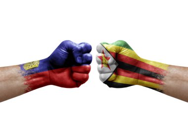 Two hands punch to each others on white background. Country flags painted fists, conflict crisis concept between liechtenstein and zimbabwe