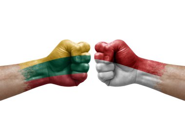 Two hands punch to each others on white background. Country flags painted fists, conflict crisis concept between lithuania and monaco