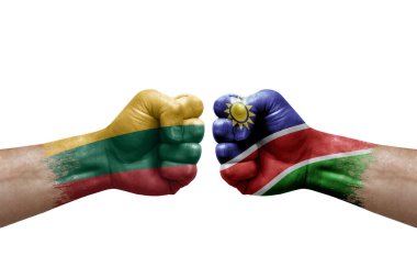 Two hands punch to each others on white background. Country flags painted fists, conflict crisis concept between lithuania and namibia