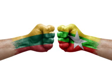 Two hands punch to each others on white background. Country flags painted fists, conflict crisis concept between lithuania and myanmar