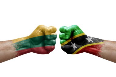Two hands punch to each others on white background. Country flags painted fists, conflict crisis concept between lithuania and saint kitts and nevis