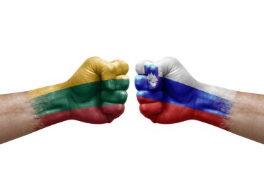 Two hands punch to each others on white background. Country flags painted fists, conflict crisis concept between lithuania and slovenia