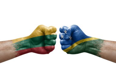 Two hands punch to each others on white background. Country flags painted fists, conflict crisis concept between lithuania and solomon islands