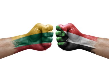 Two hands punch to each others on white background. Country flags painted fists, conflict crisis concept between lithuania and sudan