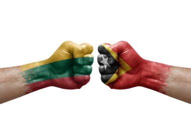 Two hands punch to each others on white background. Country flags painted fists, conflict crisis concept between lithuania and timor leste