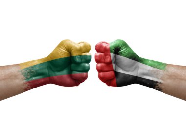 Two hands punch to each others on white background. Country flags painted fists, conflict crisis concept between lithuania and united arab emirates