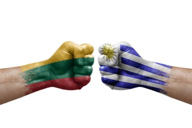 Two hands punch to each others on white background. Country flags painted fists, conflict crisis concept between lithuania and uruguay