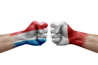 Two hands punch to each others on white background. Country flags painted fists, conflict crisis concept between luxembourg and malta