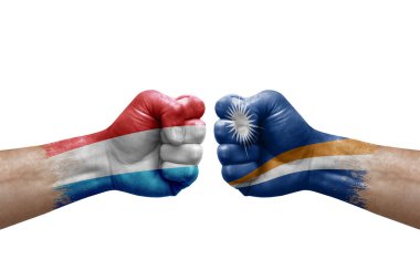 Two hands punch to each others on white background. Country flags painted fists, conflict crisis concept between luxembourg and marshall islands