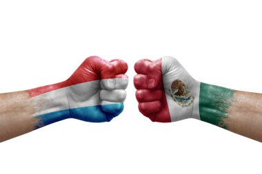 Two hands punch to each others on white background. Country flags painted fists, conflict crisis concept between luxembourg and mexico