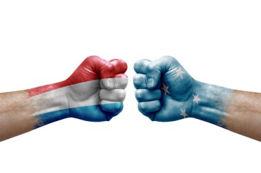 Two hands punch to each others on white background. Country flags painted fists, conflict crisis concept between luxembourg and micronesia