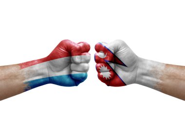 Two hands punch to each others on white background. Country flags painted fists, conflict crisis concept between luxembourg and nepal