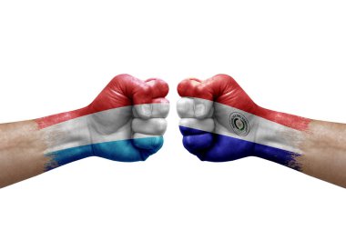 Two hands punch to each others on white background. Country flags painted fists, conflict crisis concept between luxembourg and paraguay
