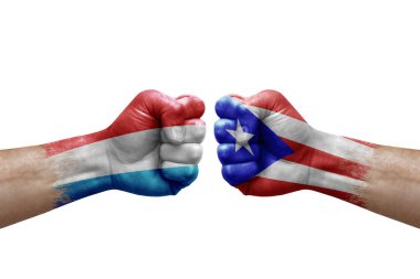 Two hands punch to each others on white background. Country flags painted fists, conflict crisis concept between luxembourg and puerto rico