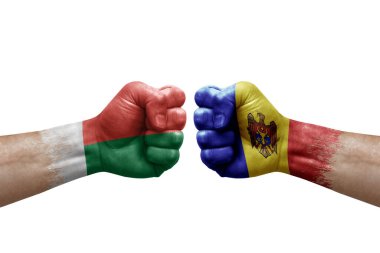 Two hands punch to each others on white background. Country flags painted fists, conflict crisis concept between madagascar and moldova
