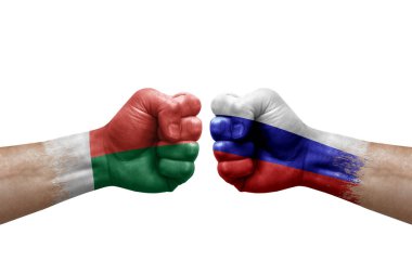 Two hands punch to each others on white background. Country flags painted fists, conflict crisis concept between madagascar and russia