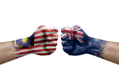 Two hands punch to each others on white background. Country flags painted fists, conflict crisis concept between malaysia and new zealand