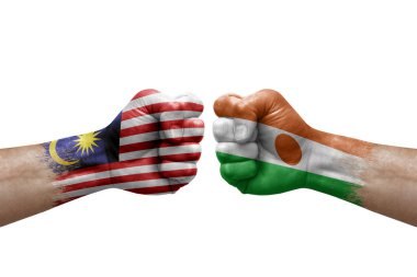 Two hands punch to each others on white background. Country flags painted fists, conflict crisis concept between malaysia and niger