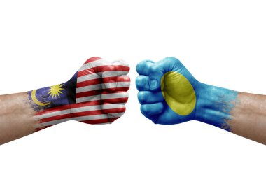 Two hands punch to each others on white background. Country flags painted fists, conflict crisis concept between malaysia and palau