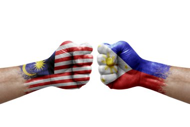 Two hands punch to each others on white background. Country flags painted fists, conflict crisis concept between malaysia and philippines