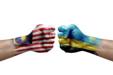 Two hands punch to each others on white background. Country flags painted fists, conflict crisis concept between malaysia and rwanda