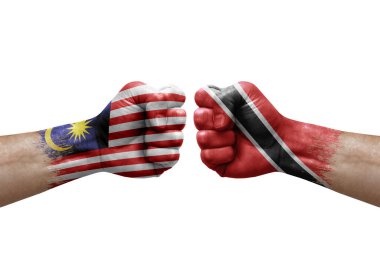 Two hands punch to each others on white background. Country flags painted fists, conflict crisis concept between malaysia and tobago