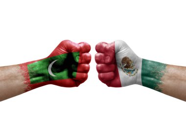 Two hands punch to each others on white background. Country flags painted fists, conflict crisis concept between maldives and mexico