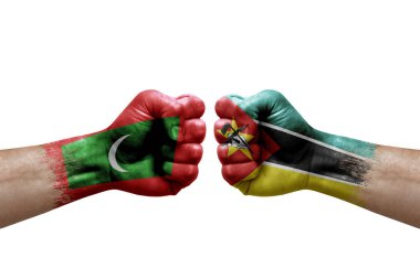 Two hands punch to each others on white background. Country flags painted fists, conflict crisis concept between maldives and mozambique