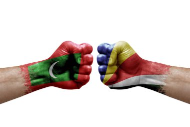 Two hands punch to each others on white background. Country flags painted fists, conflict crisis concept between maldives and seychelles