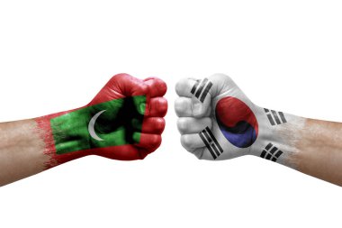 Two hands punch to each others on white background. Country flags painted fists, conflict crisis concept between maldives and south korea