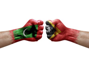 Two hands punch to each others on white background. Country flags painted fists, conflict crisis concept between maldives and timor leste