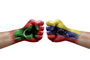 Two hands punch to each others on white background. Country flags painted fists, conflict crisis concept between maldives and venezuela