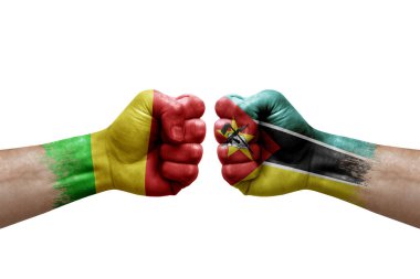 Two hands punch to each others on white background. Country flags painted fists, conflict crisis concept between mali and mozambique