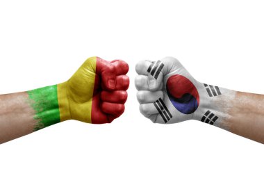 Two hands punch to each others on white background. Country flags painted fists, conflict crisis concept between mali and south korea
