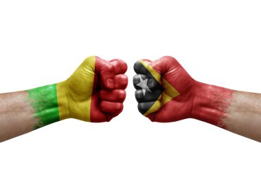 Two hands punch to each others on white background. Country flags painted fists, conflict crisis concept between mali and timor leste