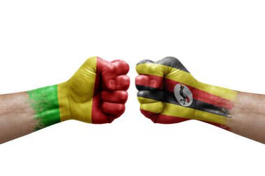 Two hands punch to each others on white background. Country flags painted fists, conflict crisis concept between mali and uganda